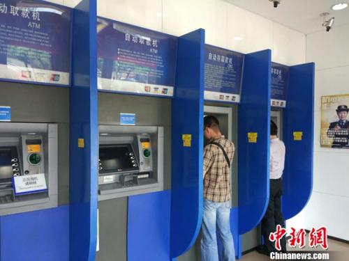 民眾在自動取款機上取款。<a target='_blank'  _fcksavedurl='http://www.chinanews.com/' ></table><p align=